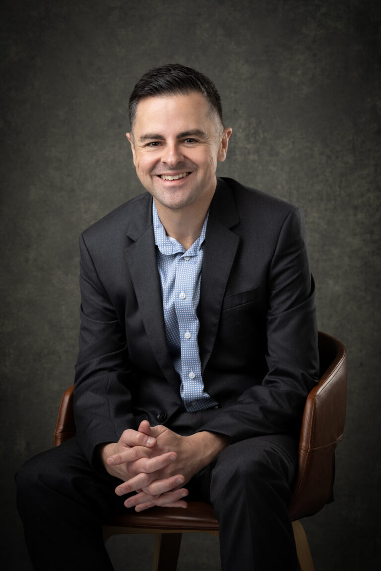 Corporate Headshot on a creative background of a businessman sitting in a chair